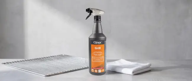 Clinex Grill preparat do czyszczenia grilli spray 1L z atomizerem, obok rusztu i ścierki.