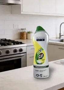 CIF Cream Lemon mleczko do szorowania 750ml Professional, butelka z żółto-zieloną etykietą na blacie kuchennym.