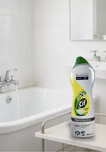 CIF Cream Lemon mleczko do szorowania 750ml Professional, butelka żółto-biała z zielonym wieczkiem na blacie łazienkowym.