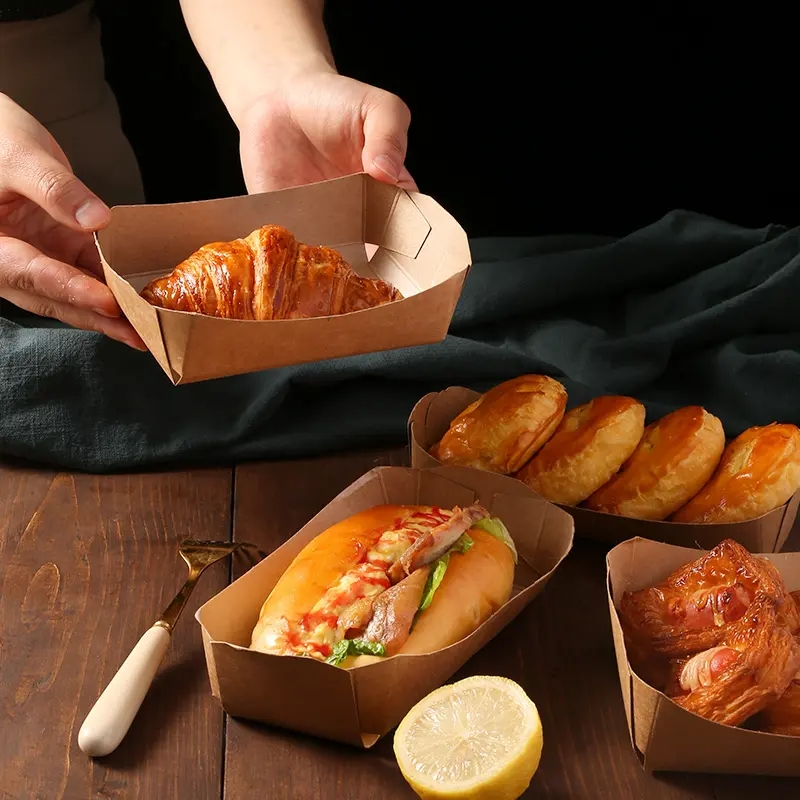 Tacka łódka kraft składana brązowa 8,5x15x5cm do żywności, na zdjęciu z croissantem i hot-dogiem